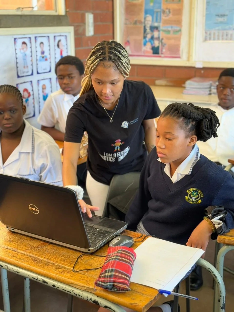 A facilitator guiding a learner using a laptop